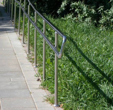 Güneşli yaz gününde parkta metal çitler