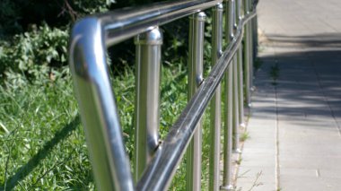 Güneşli yaz gününde parkta metal çitler