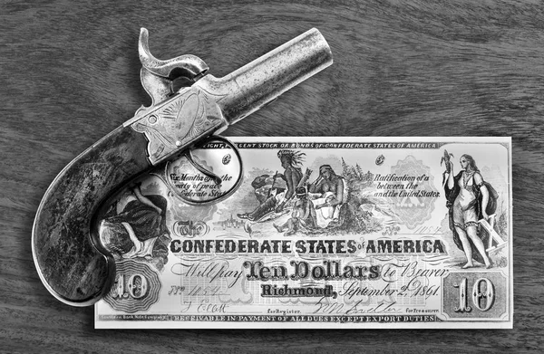 Pistola antigua y dinero confederado . — Foto de Stock