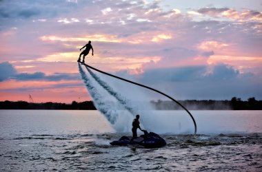 Roket Adam gün batımında Teksas, Arlington Gölü 'nde Jet Fly sörf tahtasında uçuyor. .