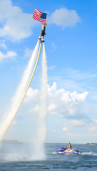 ロケットマンは テキサス州アーリントン湖のジェットフライボード上を飛行し アメリカ国旗を保持 — ストック写真