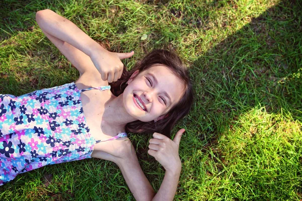 Menina Alegre Está Deitado Grama Com Polegar Para Cima — Fotografia de Stock