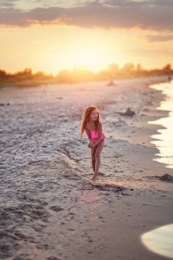 kostüm giymiş bir genç kız sahilde oynuyor