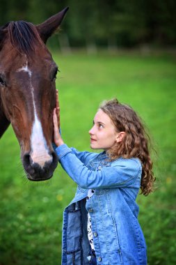 Kız çiftlikte bir at okşuyor