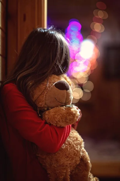 Malá Dívka Objímá Medvídka Večer Doma — Stock fotografie