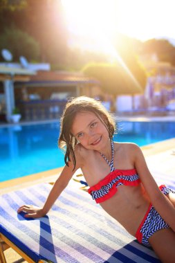 Havuzda mayo giymiş neşeli bir kız