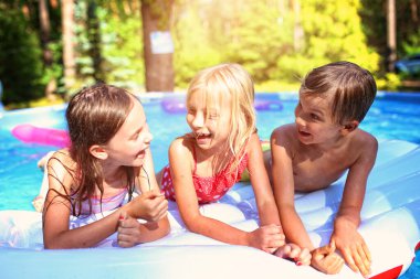 Çocuklar sıcak bir günde havuzda eğlenirler.