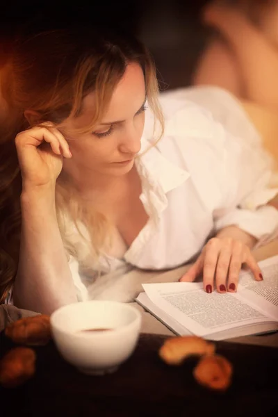 Μια Σκεπτική Γυναίκα Διαβάζει Ένα Βιβλίο Στο Σπίτι — Φωτογραφία Αρχείου