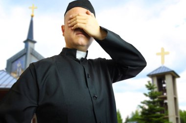 Kilisedeki rahip gözlerini kapatıyor.