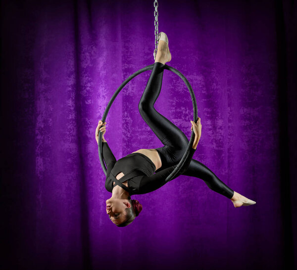 Young woman doing gymnastic exercises on the hoop