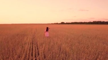 Genç kız buğday sahada yürüyüş
