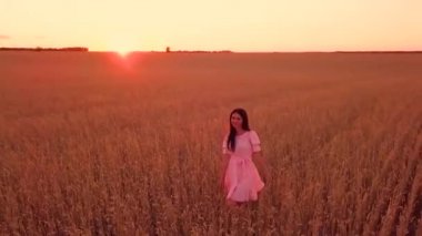 Genç kız buğday sahada yürüyüş