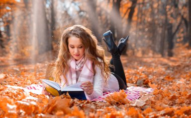 Güneşli bir gün, sonbahar ormandaki genç kız