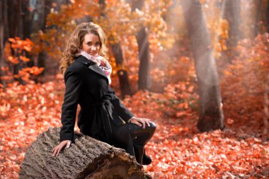 Güneşli sonbahar orman içindeki genç kız