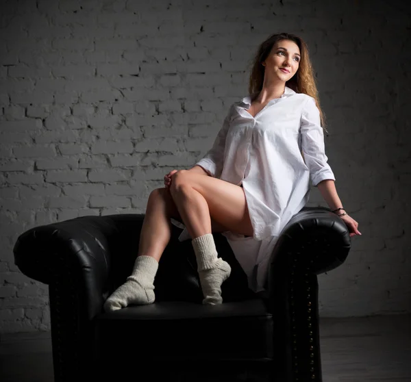 黒い肘掛け椅子に若い女性 — ストック写真