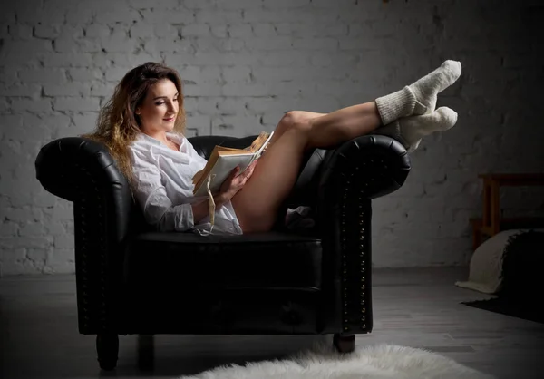 Junge Frau auf Sessel mit Buch — Stockfoto