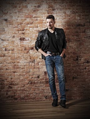 Tuğla duvar üzerinde deri giysiler adam (HDR ver)