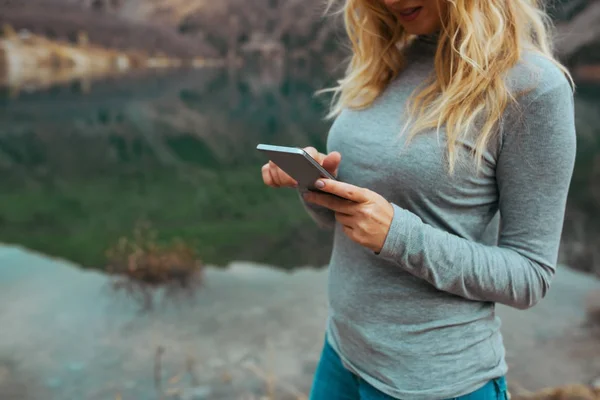 Vrouw Met Behulp Van Smartphone Aan Het Meer — Stockfoto