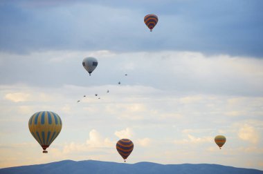 Sıcak hava balonları ve dağların üzerinden uçan kuşlar