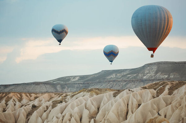 Три воздушных шара, летящих над скалами Каппадокии, Турция

