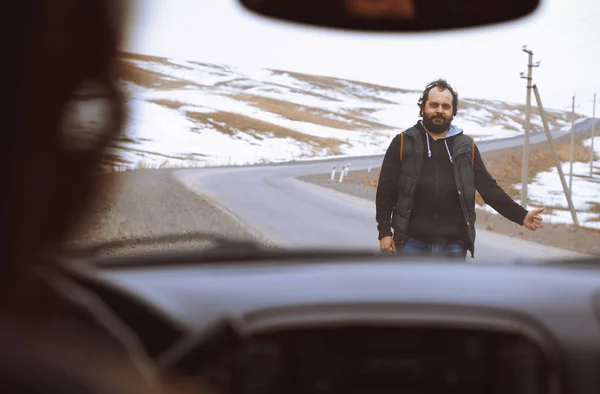 Ταξιδιώτης στον αγροτικό δρόμο που προσπαθεί να σταματήσει ένα αυτοκίνητο για βοήθεια — Φωτογραφία Αρχείου