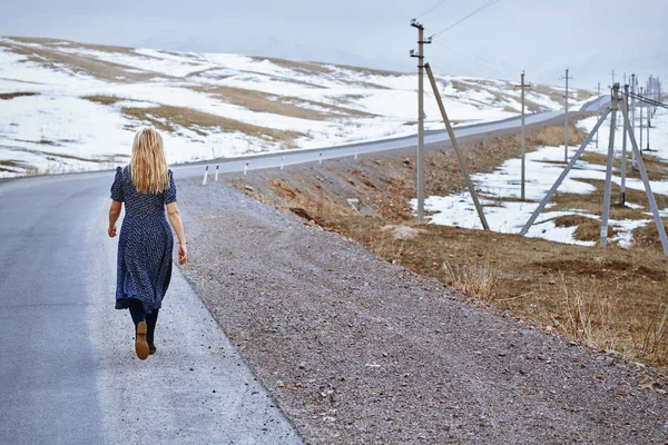 Woman walking along the rural highway — Stock Photo, Image
