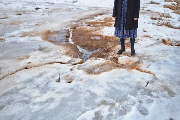 Woman standing at the puddle in winter landscape — Stock Photo, Image