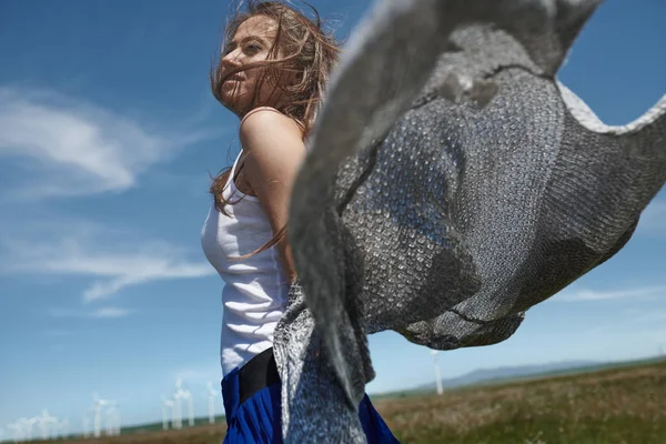 Kvinna med långt rufsigt hår bredvid vindkraftverk med w — Stockfoto