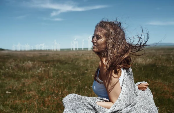 Kvinna med långt rufsigt hår bredvid vindkraftverk med w — Stockfoto