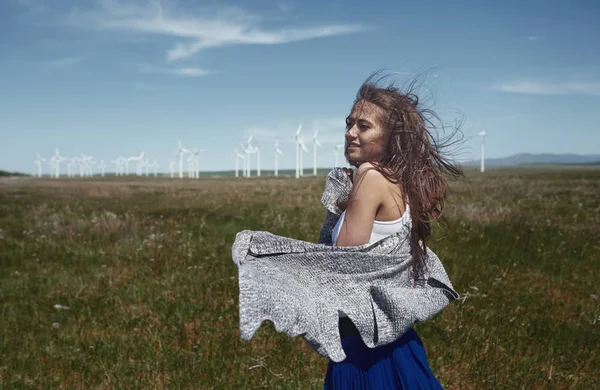 Vrouw met lang tousleed haar naast de windturbine met de w — Stockfoto