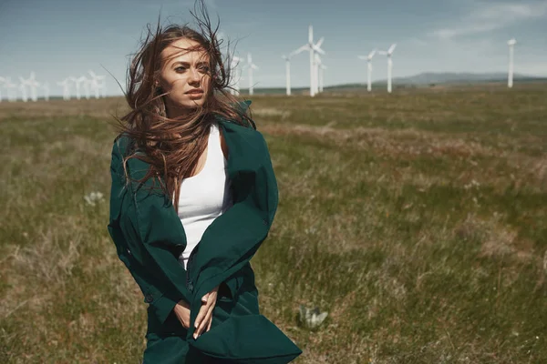 Vrouw met lang tousleed haar naast de windturbine met de w — Stockfoto