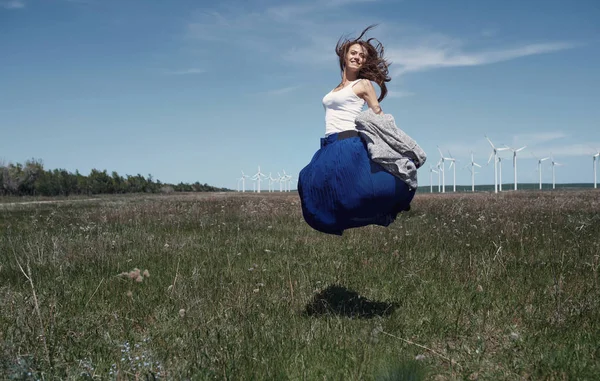 Vrouw met lang tousleed haar naast de windturbine met de w — Stockfoto