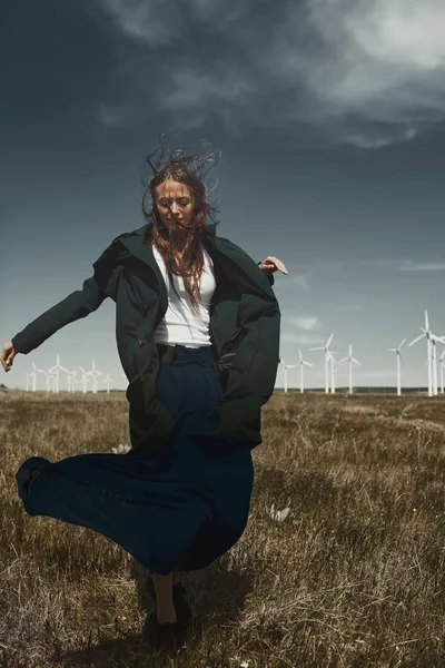 Rüzgâr türbininin yanındaki uzun saçlı kadın. — Stok fotoğraf