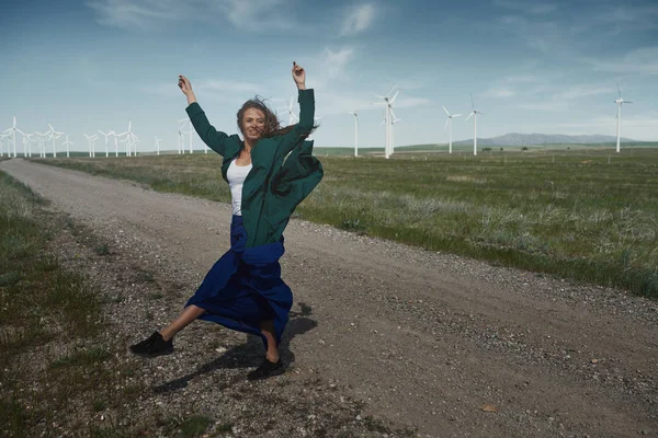 Femme avec de longs cheveux ébouriffés à côté de l'éolienne avec le w — Photo