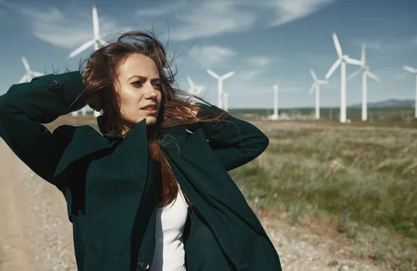 Femme avec de longs cheveux ébouriffés à côté de l'éolienne avec le w — Photo