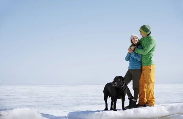 Mladý dospělý pár venku se psem baví v zimě landsc — Stock fotografie