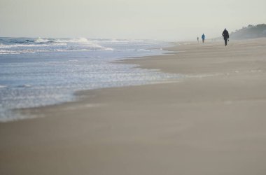Atlantik Okyanusu sahillerinde yürüyen tesadüfi insanlar. ABD