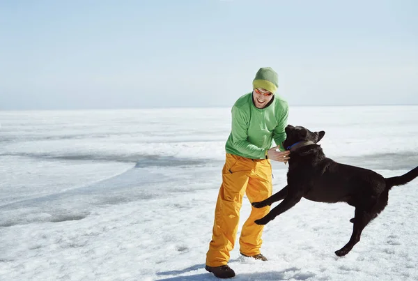 Młody Dorosły Mężczyzna Zewnątrz Jego Pies Zabawy Zimowym Krajobrazie — Zdjęcie stockowe