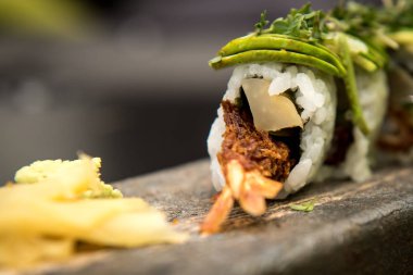 Suşi karides ile taş bir plaka üzerinde rulo.