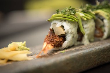 Suşi karides ile taş bir plaka üzerinde rulo.