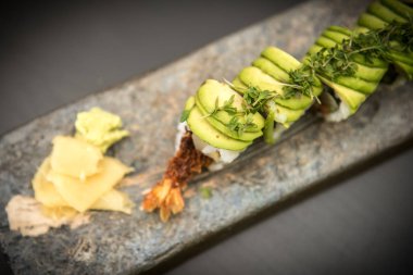 Suşi karides ile taş bir plaka üzerinde rulo.