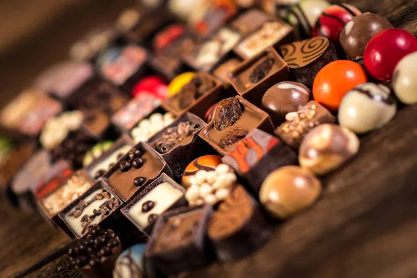 Pralinés de chocolate surtidos en el fondo de madera —  Fotos de Stock