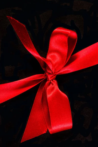 Red ribbon on a black background — Stock Photo, Image