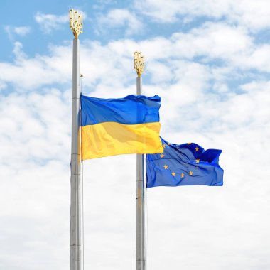 Adamların arka plan olarak mavi gökyüzü ile Avrupa ve Ukrayna bayrakları