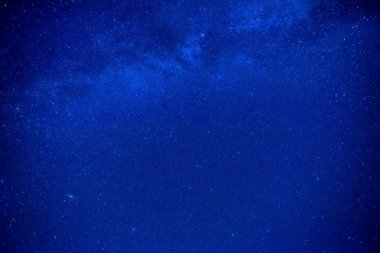 Bir sürü yıldızı ve Samanyolu Galaksisi olan gece mavisi gökyüzü