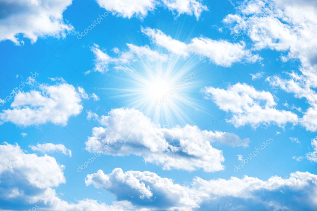 Sun with sun rays and clouds on blue sky as nature background