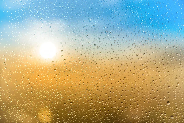 雨の降るガラス越しに美しい夕日が落ちる — ストック写真