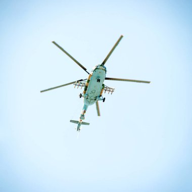 Mavi gökyüzünde uçan askeri helikopter