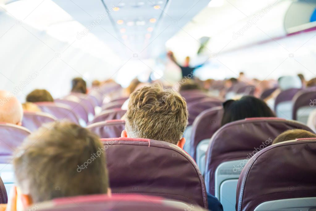 rear view of passengers sitting inside airplane 