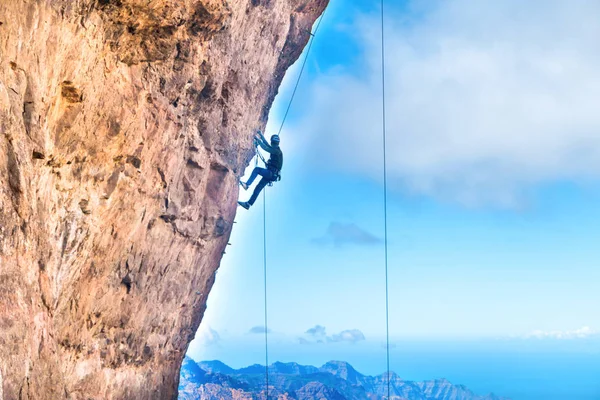 攀岩者爬上悬崖峭壁与加那利岛山脉和海的背景 — 图库照片